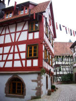 Decorative half-timbered construction and quoins (prominent stones at wall corners or door and window openings) of the Jägerhäusle, built into the city wall of this perfectly preserved town in the Kinzig Valley surrounded by sunny forested slopes & shady valleys.